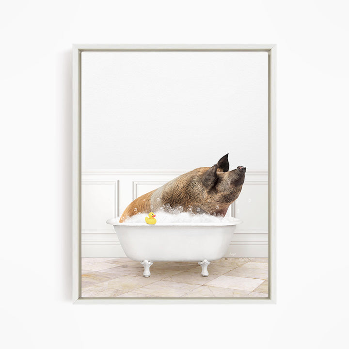 A brown and black pig is sitting in a white bathtub filled with bubbles, with a yellow rubber duck floating in the water.
