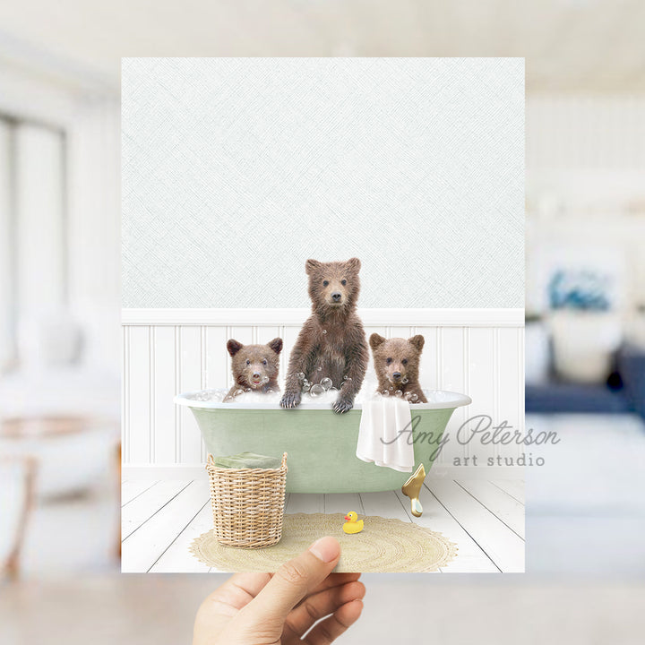 a person holding a card with three bears in a bathtub