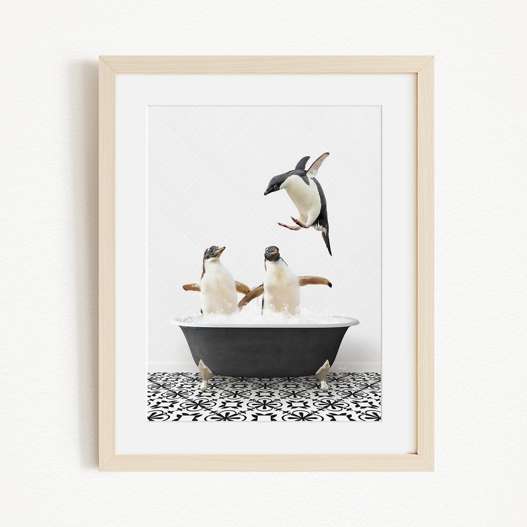 A framed image depicting two penguins sitting in a bathtub, with one penguin flying towards the other.