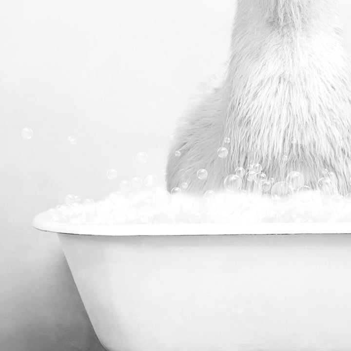 a polar bear sitting in a bathtub filled with bubbles