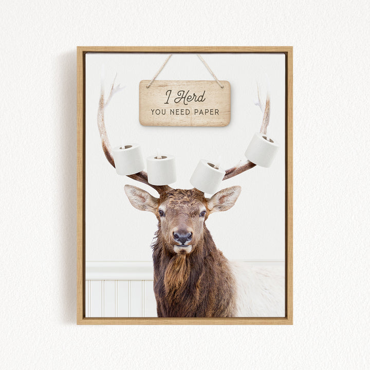 A deer with antlers is standing in front of a sign that says "I herd you need paper".