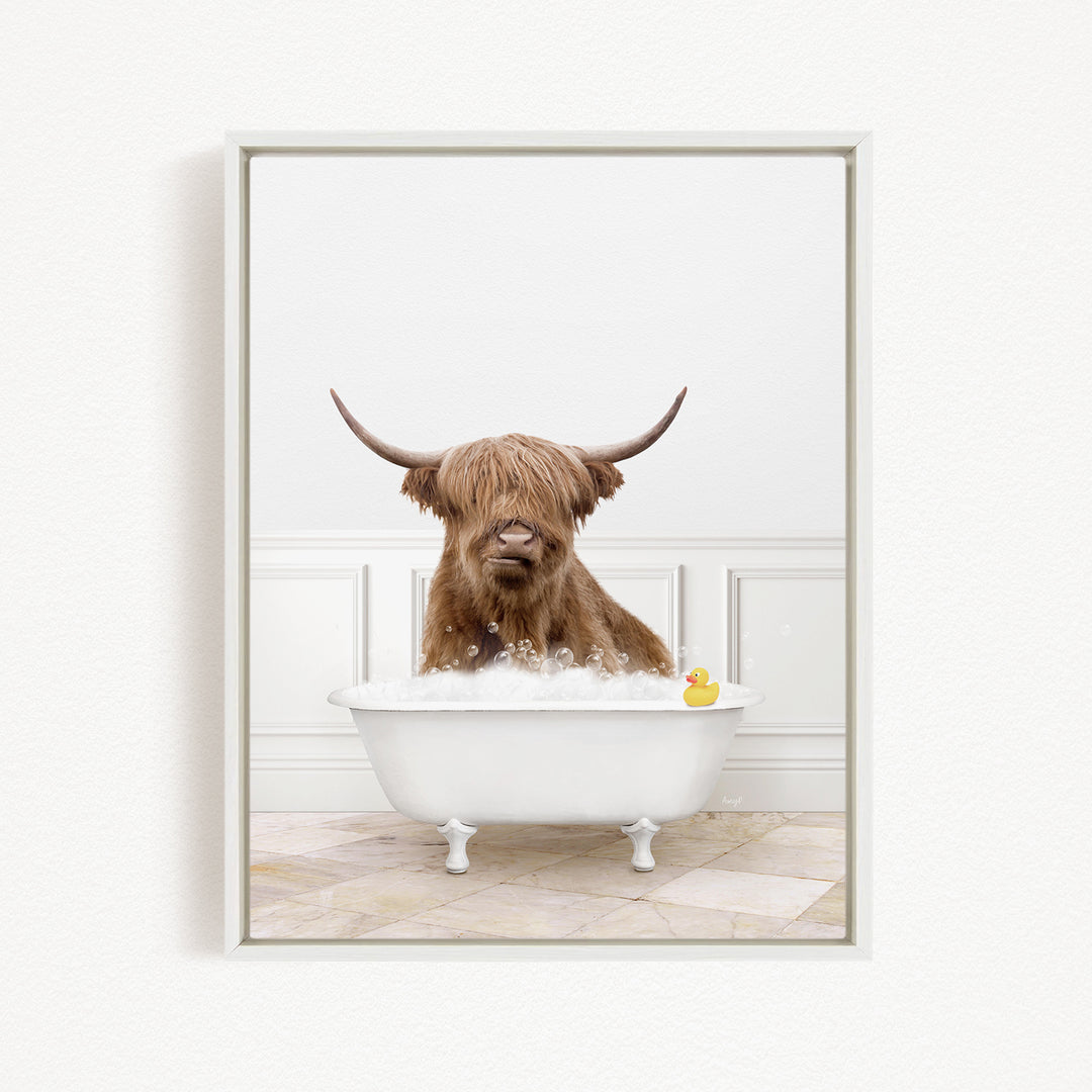 A brown cow with long horns is sitting in a white bathtub filled with bubbles, with a yellow rubber duck floating in the water.