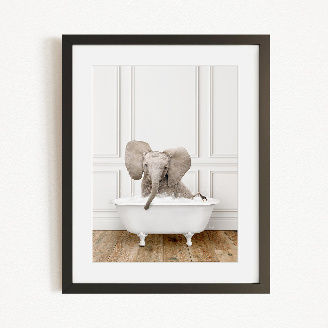 A baby elephant sitting in a white bathtub, with its trunk submerged in the water.
