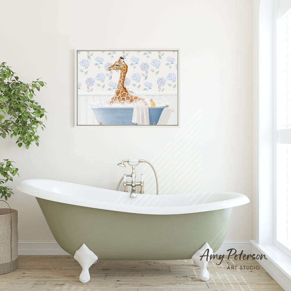A green clawfoot bathtub with a giraffe sitting in it, surrounded by blue flowers, is the focal point of the image. Above the bathtub, there is a framed picture of a giraffe. The bathroom has white walls and a window, creating a serene and relaxing atmosphere.