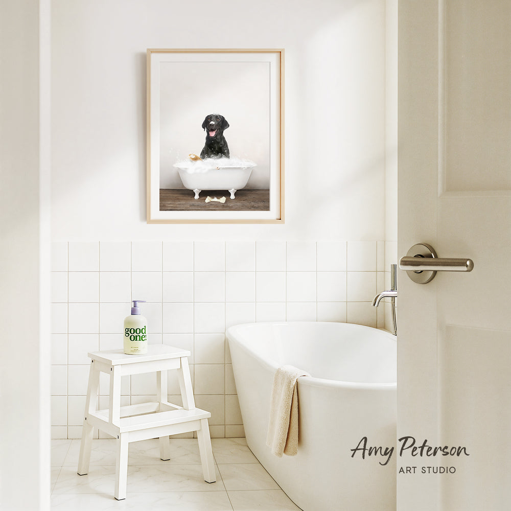 A framed image of a black dog sitting in a white bathtub, with a bottle of soap and a towel nearby, in a clean and minimalist bathroom setting.