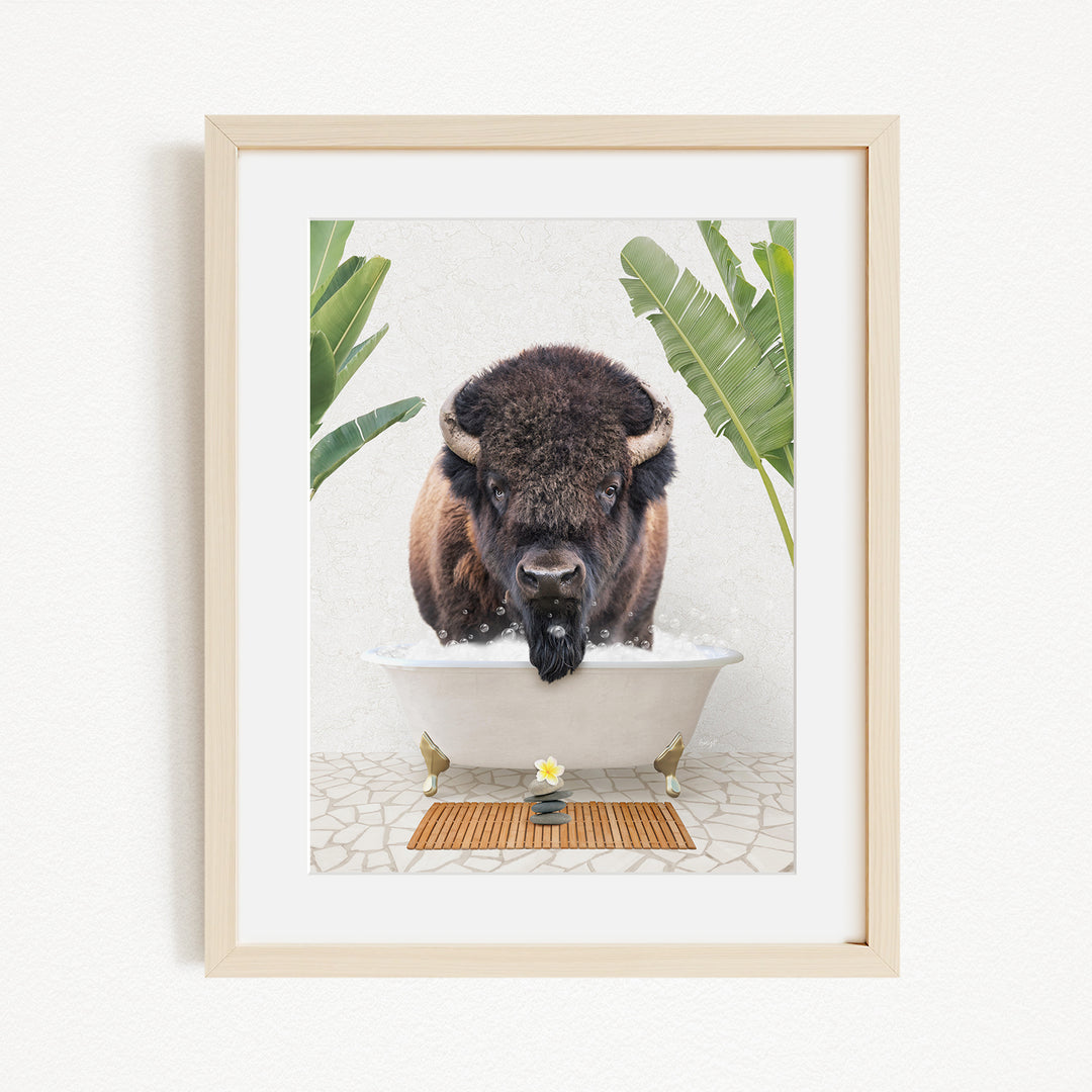 A buffalo is taking a bath in a white tub, surrounded by green plants and a wooden mat on the floor.