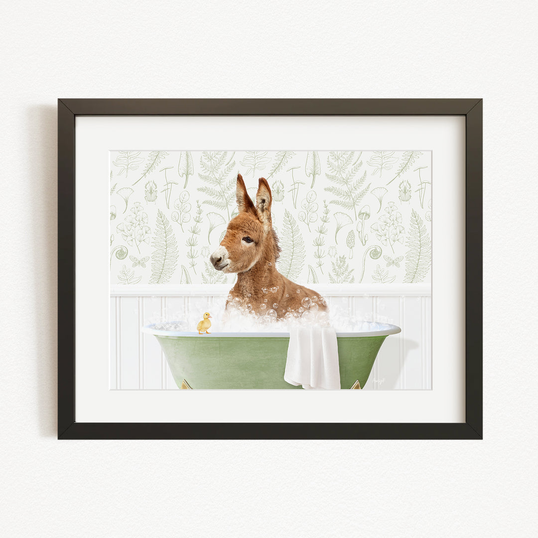 A brown donkey is sitting in a green bathtub filled with water, surrounded by a white wall with a green plant pattern.