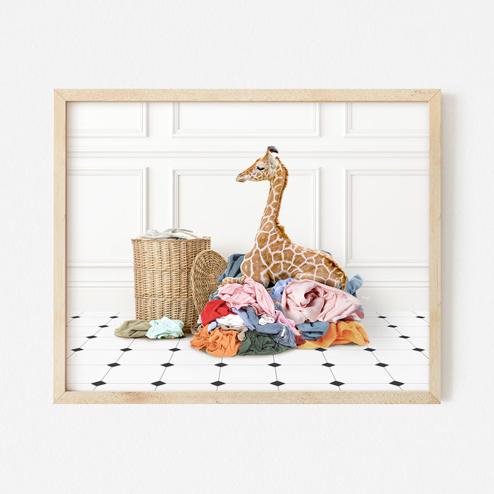 a giraffe sitting on top of a pile of clothes