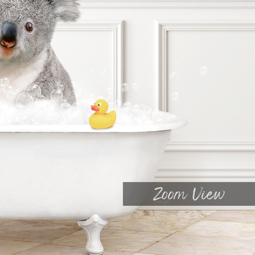 A koala bear sitting in a bathtub filled with bubbles, with a rubber duck floating nearby.