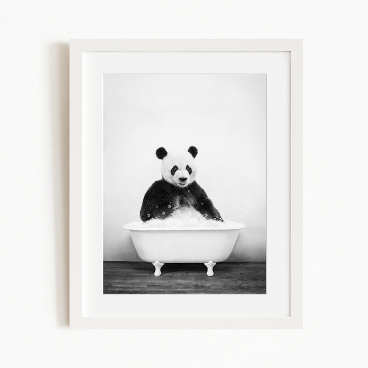 A panda bear sitting in a white bathtub filled with bubbles, creating a whimsical and playful scene.