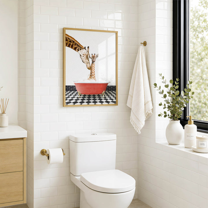 a bathroom with a white toilet, a framed picture of a giraffe in a bathtub, and a towel hanging on the wall.