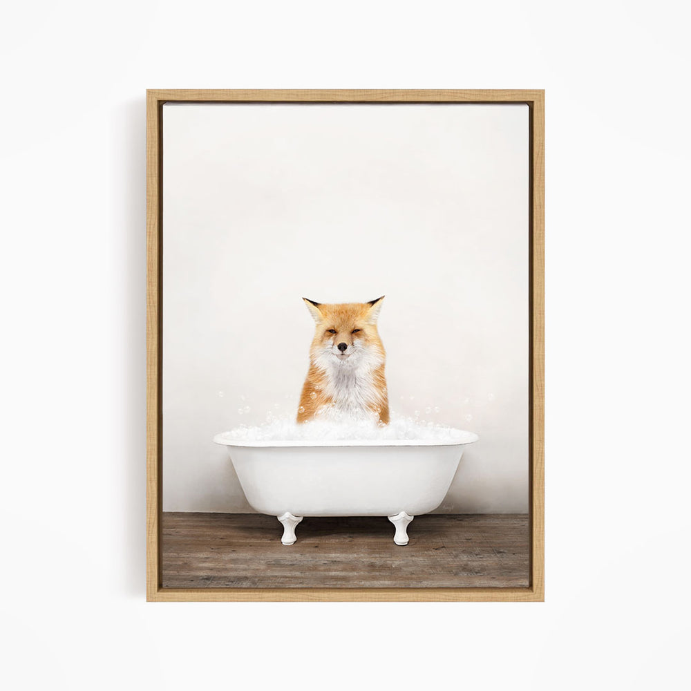 A red fox sitting in a white bathtub filled with bubbles, looking directly at the camera.