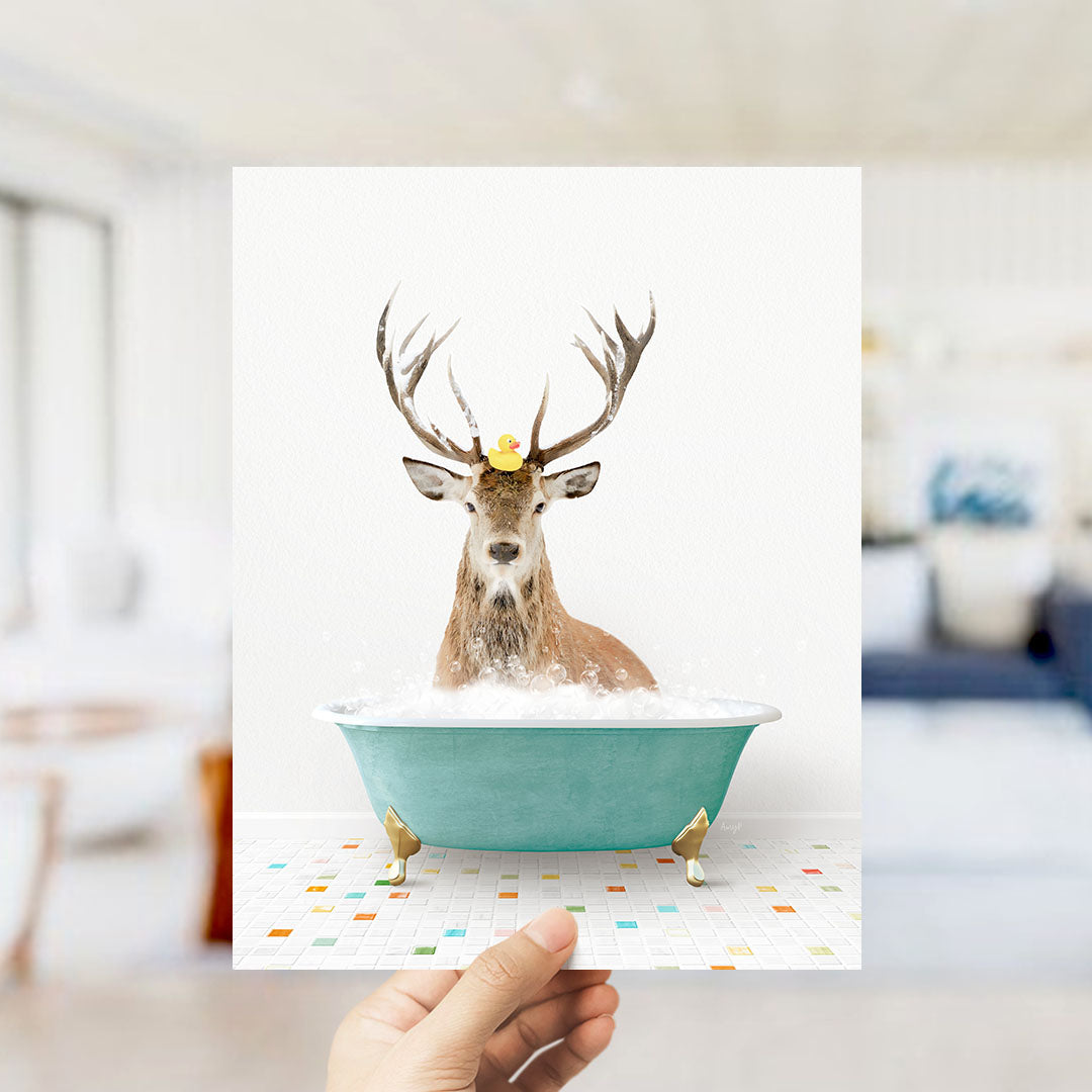 A deer with antlers is sitting in a green bathtub filled with bubbles, with a rubber duck floating on its head.
