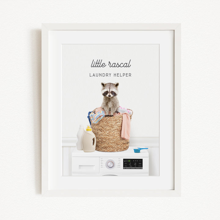 A raccoon sitting on a basket filled with laundry, with a washing machine and various household items in the background.