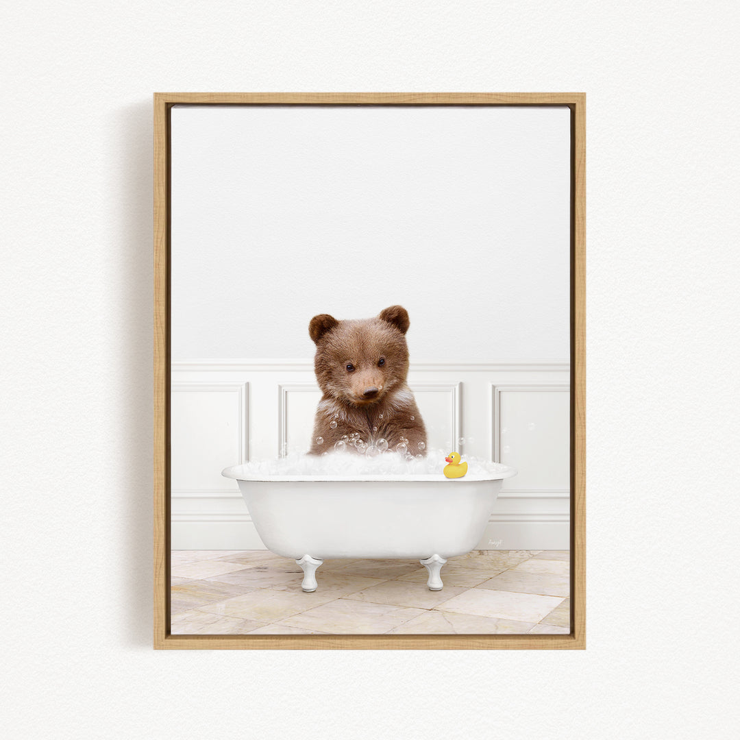 A brown bear sitting in a white bathtub filled with bubbles, with a rubber duck floating nearby.