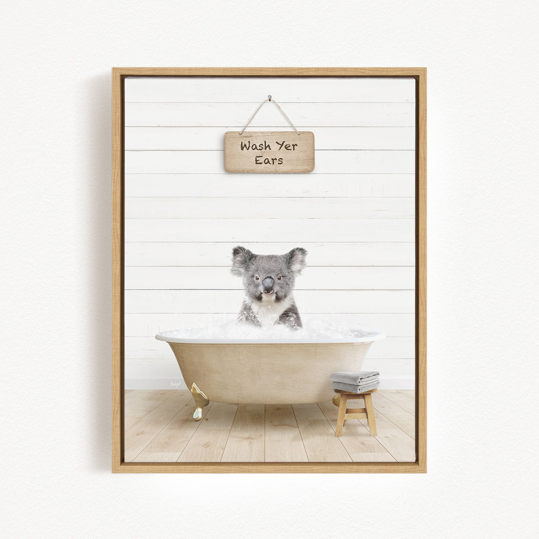 A koala sitting in a bathtub, with a sign above that says "Wash Your Ears".