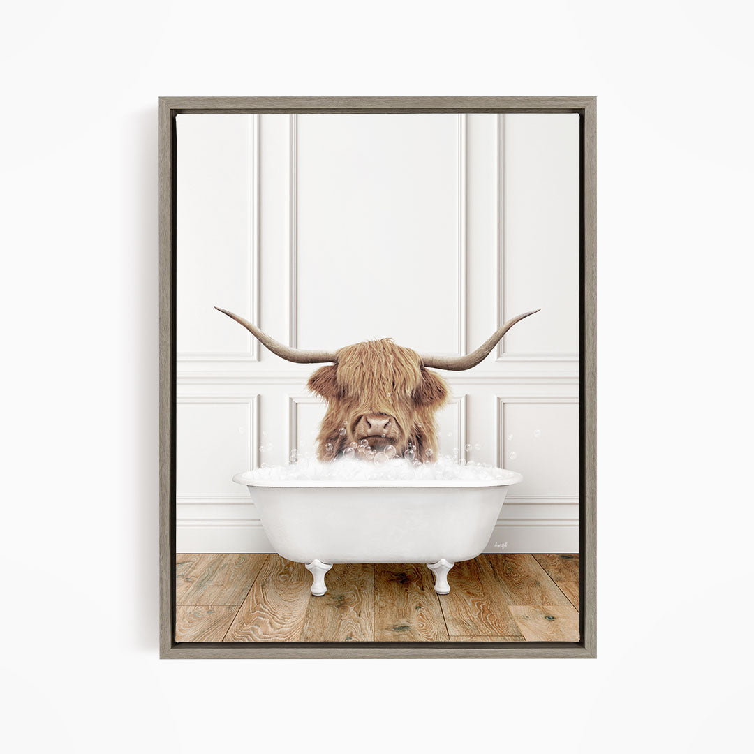 A Highland cow with long horns is sitting in a white bathtub, appearing to enjoy the bath.