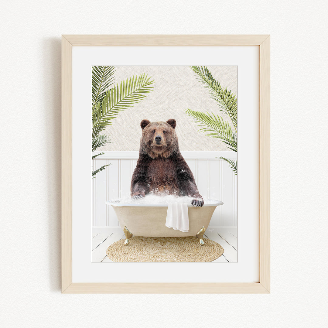 A brown bear sitting in a white bathtub, surrounded by green palm leaves, creating a whimsical and playful scene.