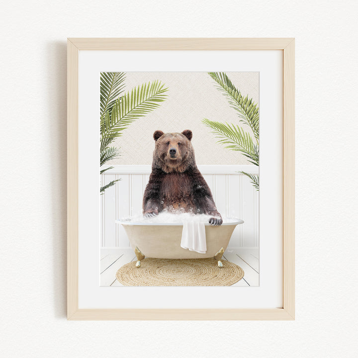 A brown bear sitting in a white bathtub, surrounded by green palm leaves, creating a whimsical and playful scene.