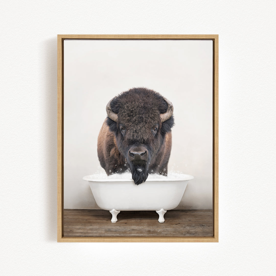 A buffalo with large horns is standing in a white bathtub filled with water, creating a whimsical and humorous scene.