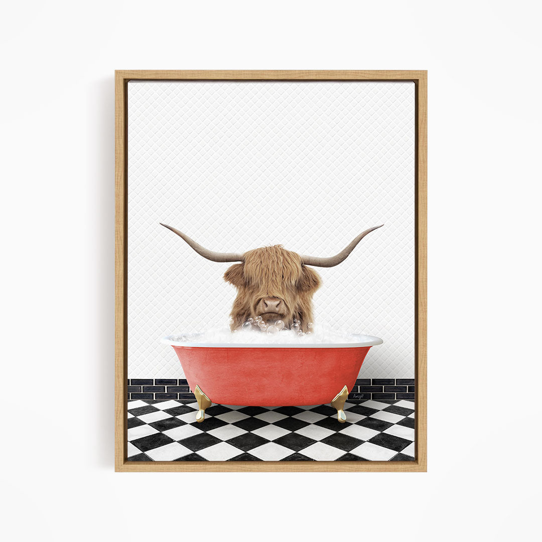 A Highland cow with large horns is sitting in a red bathtub filled with water, creating a whimsical and playful scene.