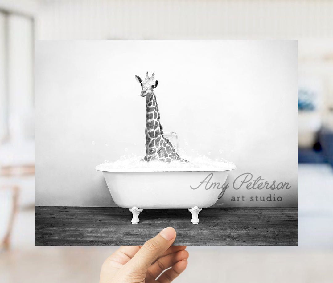 a hand holding up a picture of a giraffe in a bathtub