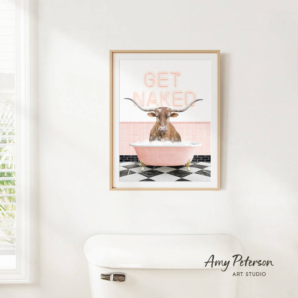 a framed print of a bull with horns sitting in a pink bathtub, with the text "GET NAKED" displayed above it.