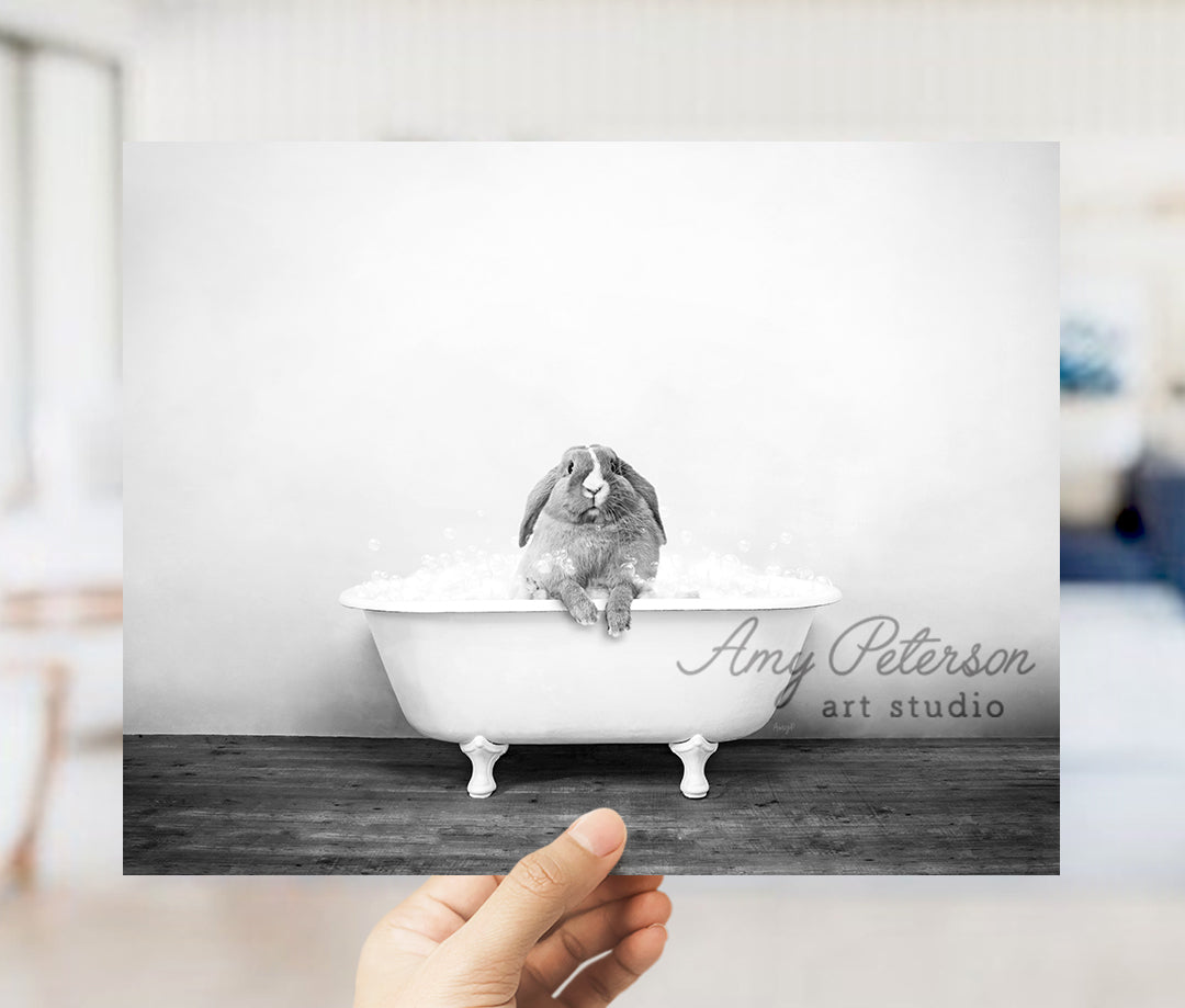 a person holding up a picture of a rabbit in a bathtub