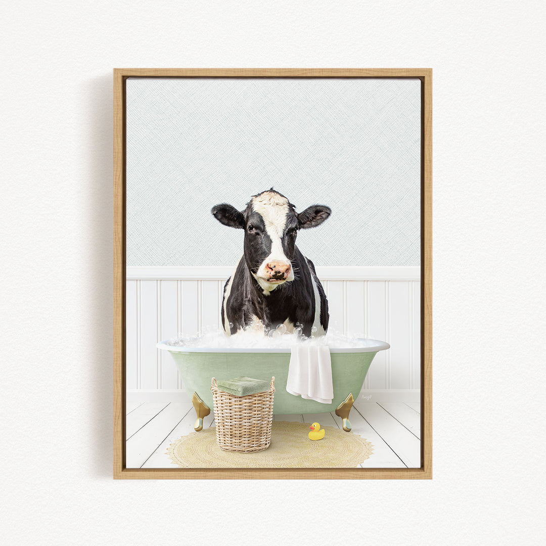 A black and white cow is sitting in a green bathtub filled with water, surrounded by rubber ducks and a basket.