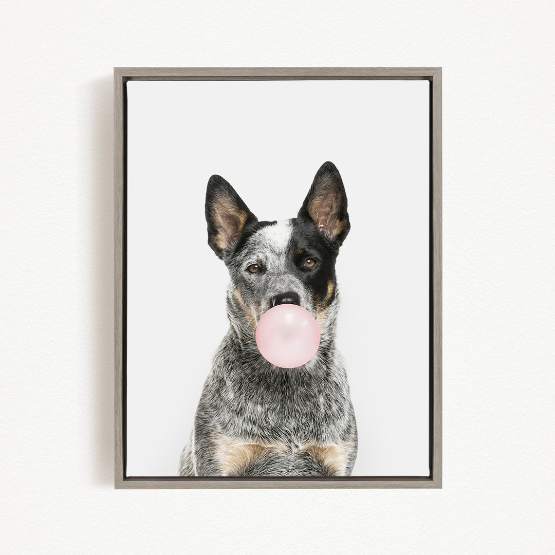 A black and white dog is blowing a pink bubble with its mouth, creating a playful and whimsical scene.