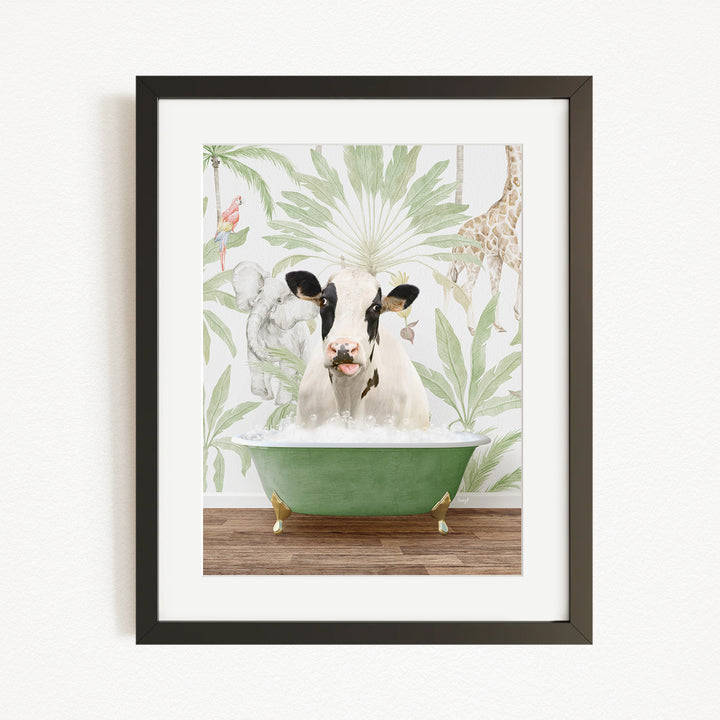 A framed image depicting a cow sitting in a green bathtub, surrounded by tropical foliage and animals.