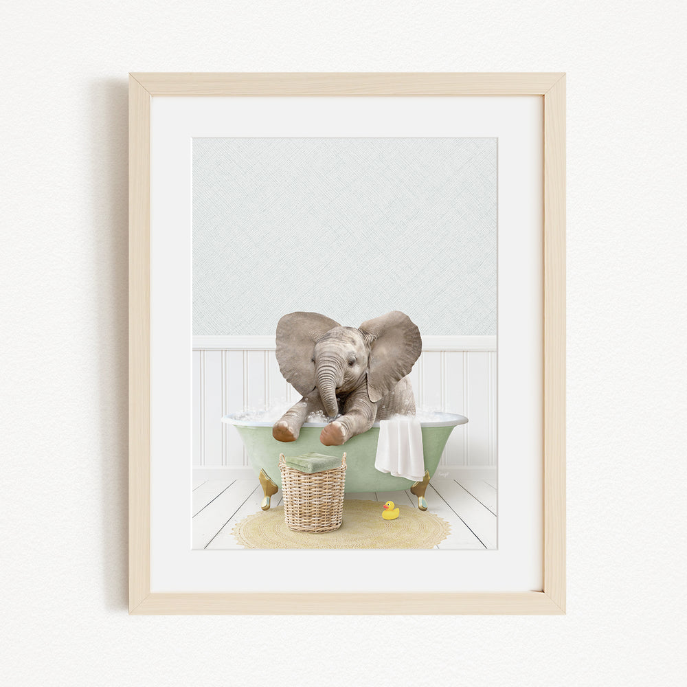 A baby elephant sitting in a green bathtub, surrounded by rubber ducks and a basket.