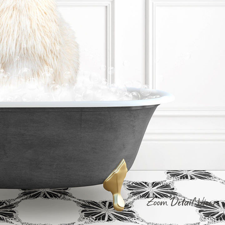 A fluffy white cat is sitting in a bathtub filled with bubbles, with a gold claw-like object on the floor.