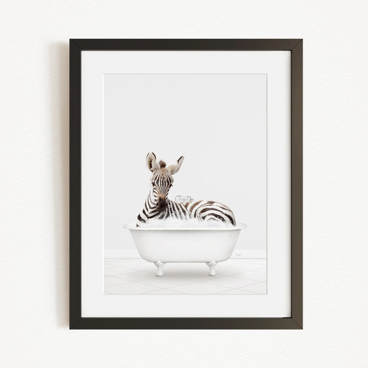 A zebra is sitting in a white bathtub, surrounded by bubbles, in the center of the image.