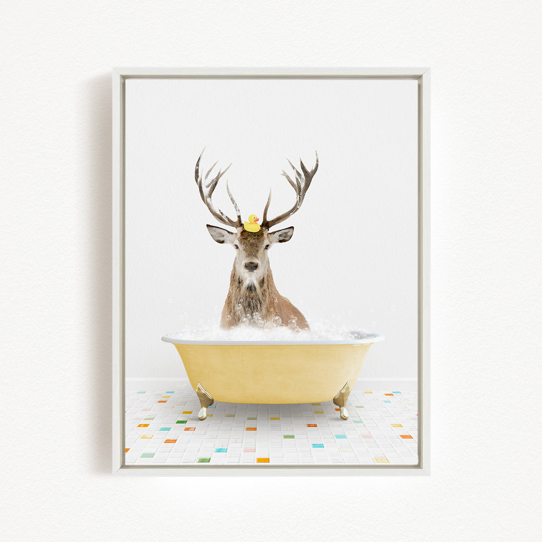 A deer with antlers is sitting in a yellow bathtub filled with bubbles, with a rubber duck perched on its head.