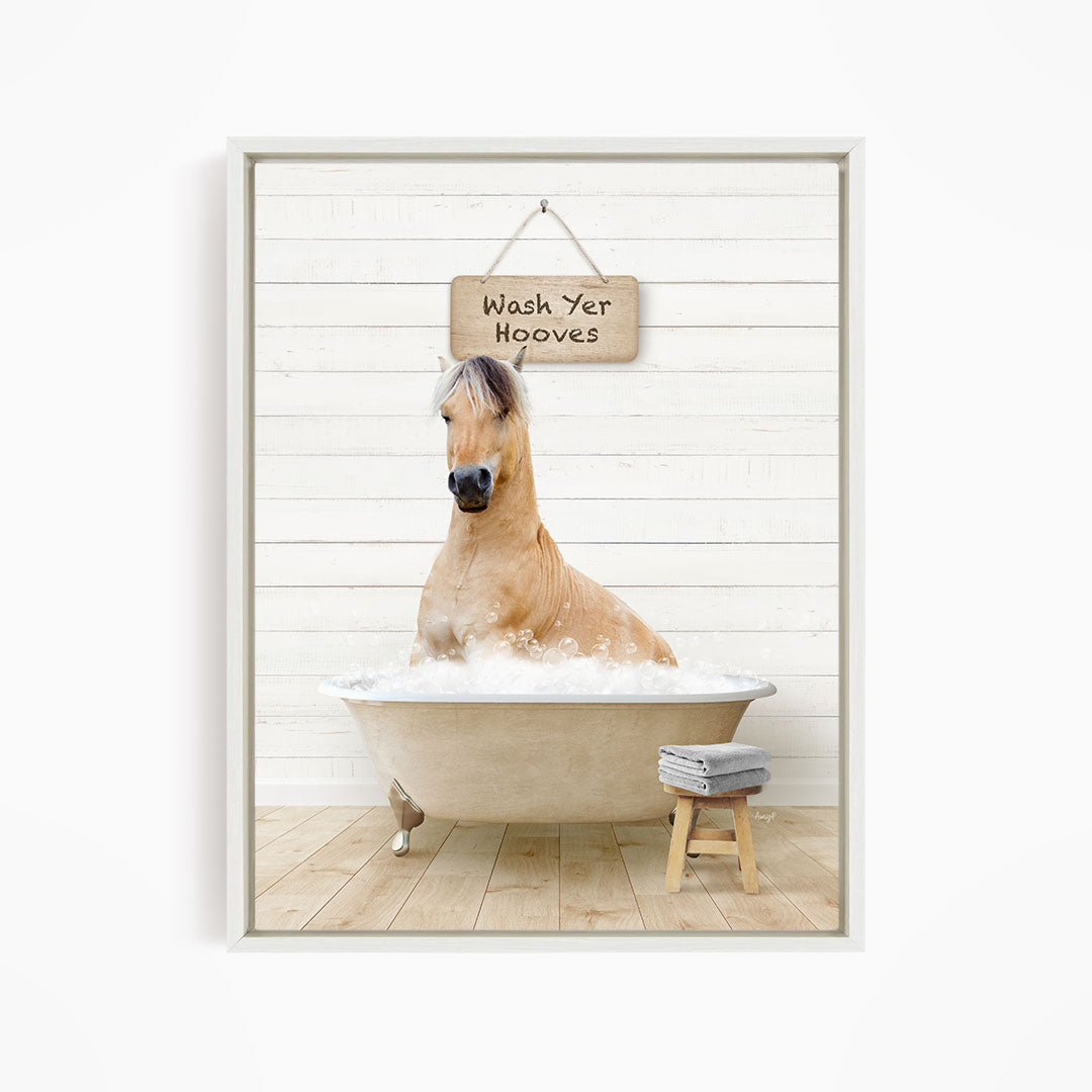 A light brown horse is sitting in a bathtub filled with water, with a sign above it that says "Wash Yer Hooves".