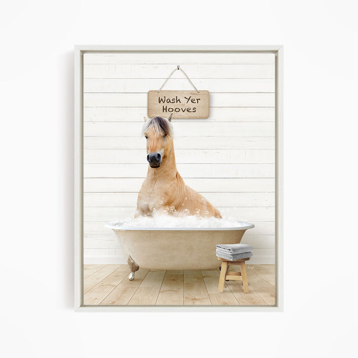 A light brown horse is sitting in a bathtub filled with water, with a sign above it that says "Wash Yer Hooves".