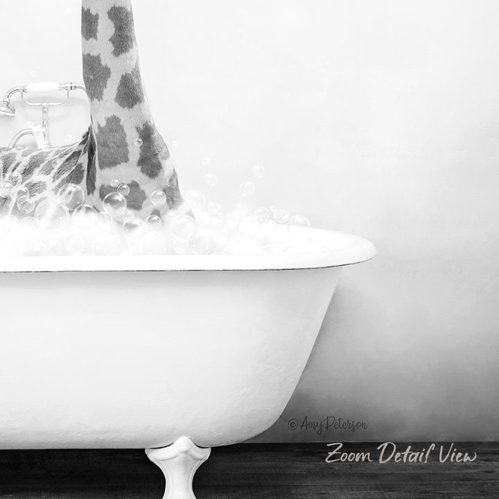A close-up black and white image of a white bathtub filled with bubbles, with a giraffe's leg partially submerged in the water.