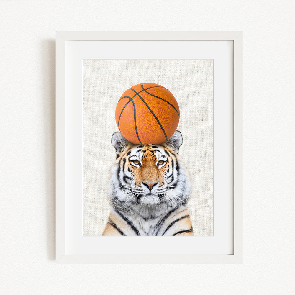 A tiger is sitting on a basketball, with the basketball positioned on top of its head.