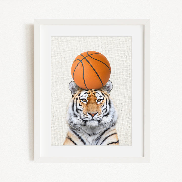 A tiger is sitting on a basketball, with the basketball positioned on top of its head.