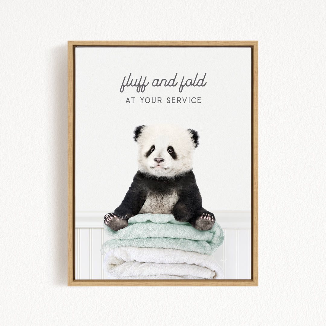 A panda bear sitting on a stack of towels, with the text "fluff and fold at your service" written above the image.
