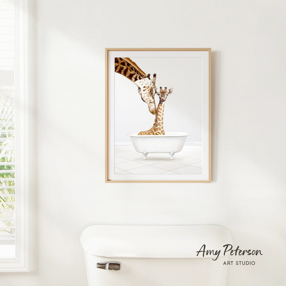 A framed painting of two giraffes sitting in a bathtub, with one giraffe appearing to be bathing the other.