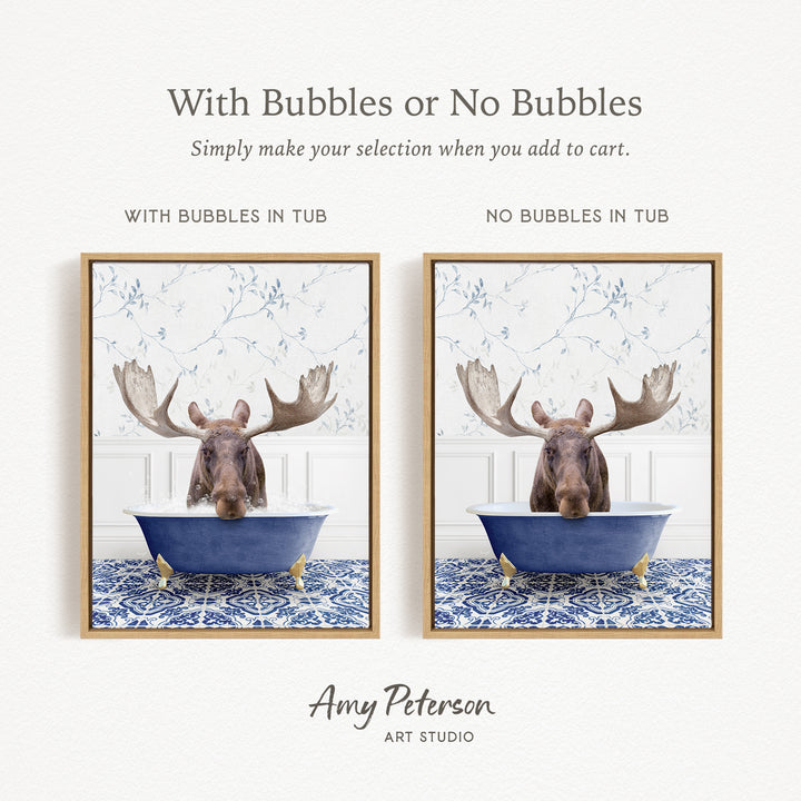The image is a framed print featuring a moose in a bathtub, with the moose's antlers visible. The moose is positioned in a blue tub, and the background has a blue and white floral pattern. The moose is looking directly at the camera.