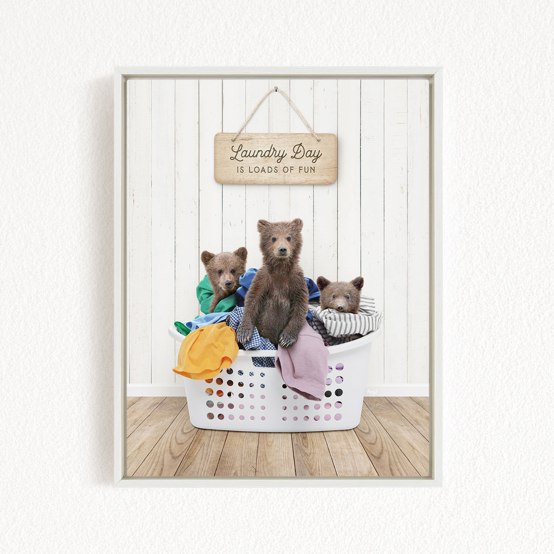 A framed image of three bears sitting in a laundry basket, with a sign above them that says "Laundry Day is loads of fun".