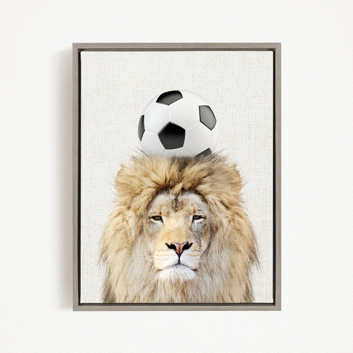 A framed image of a lion with a soccer ball on its head.