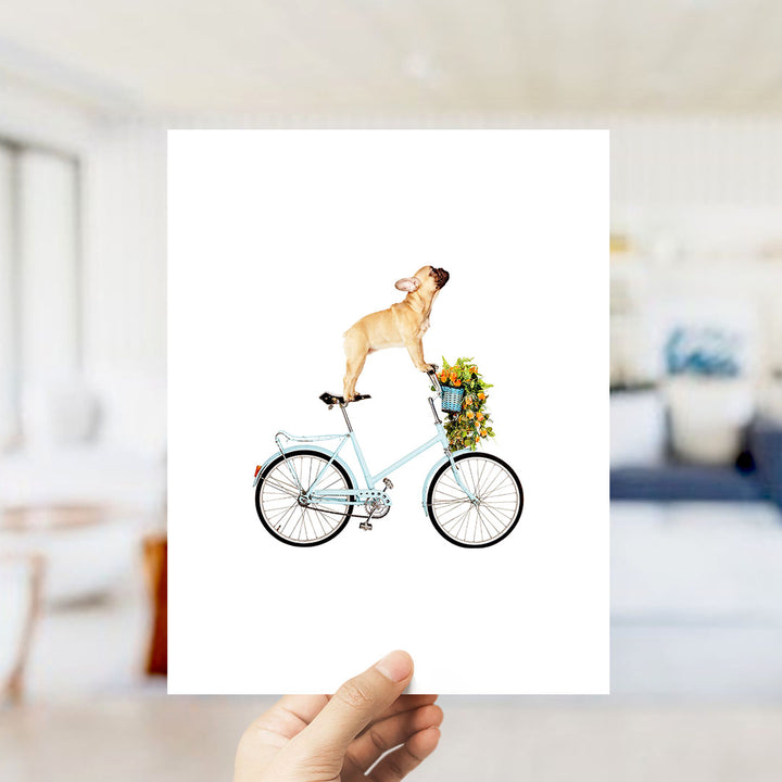 A dog is riding a bicycle with a basket of flowers on it.