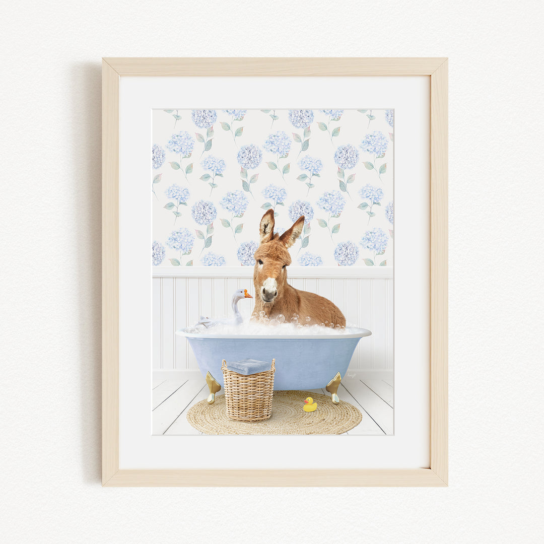A donkey is sitting in a blue bathtub filled with bubbles, surrounded by various bath toys, including rubber ducks and a stuffed animal.