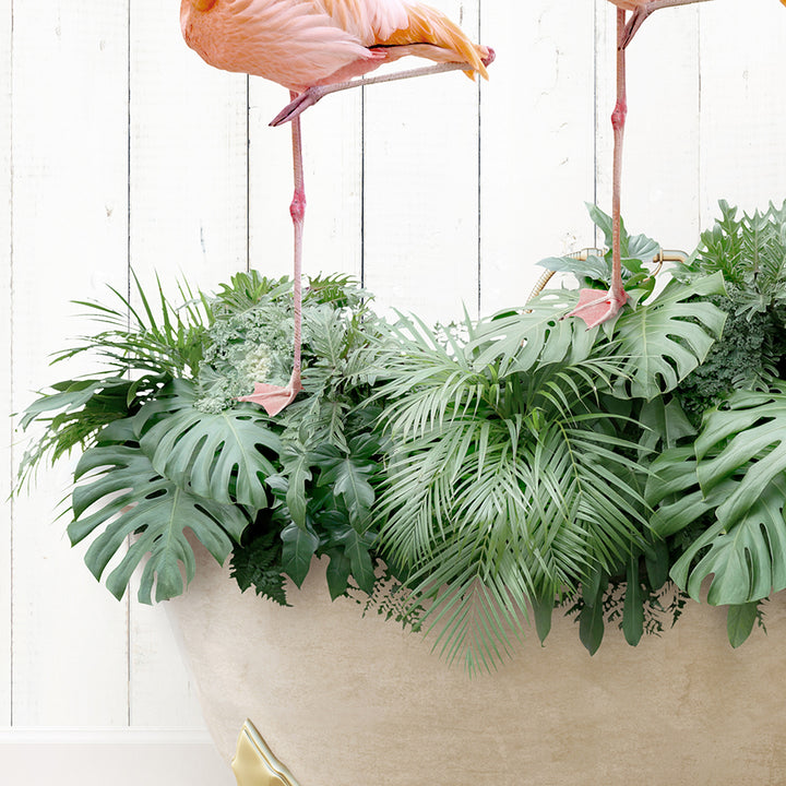 two flamingos standing on top of a plant pot