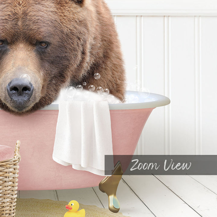 A large brown bear is sitting in a pink bathtub filled with bubbles, surrounded by a yellow rubber duck and a white basket.