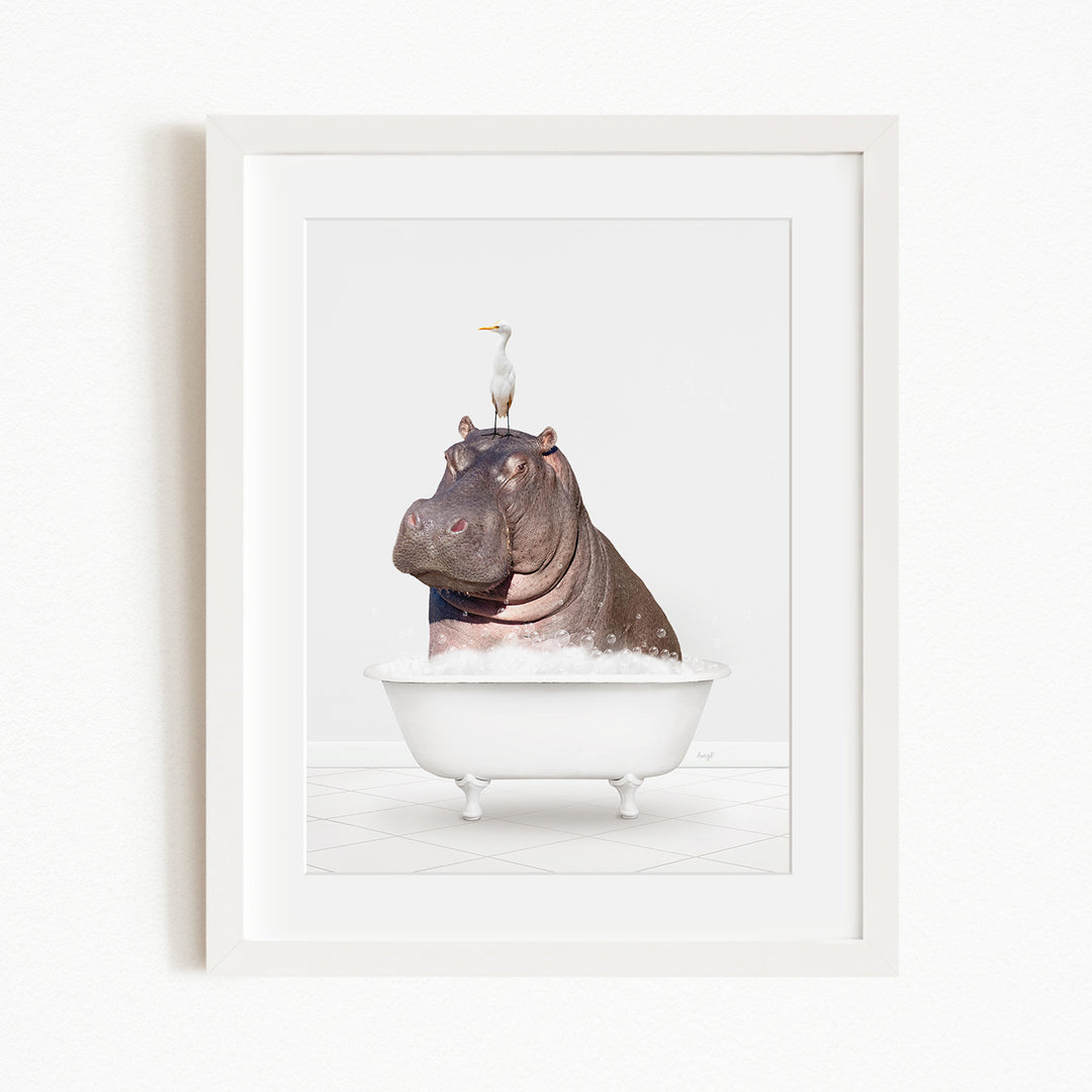 A framed image depicting a large hippopotamus sitting in a bathtub, with a seagull perched on its head.